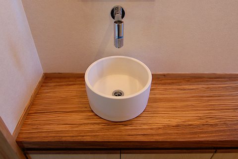 写真：無垢のシマダモのカウンターとドイツデザインの手洗い器